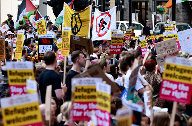 People hold anti-racist placards as they take part in a "Stop the Far-right" demonstration on a National Day of Protest, outside of the headquarters of the Reform UK political party, in London. (File/AFP)