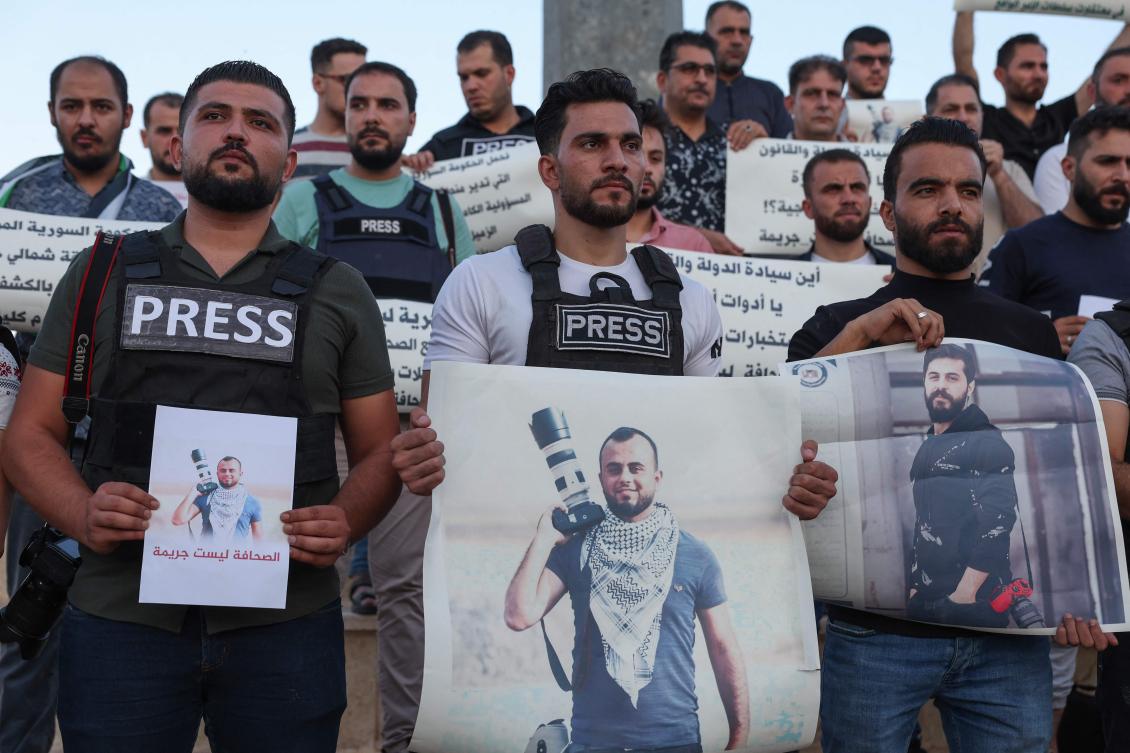 TOPSHOT - Syrian journalists lift placards protesting the detention of colleague Bakr al-Kassem a day earlier, and calling for his release along with other detained reporters, during a rally in Syria's rebel-held northern city of Idlib. (File/AFP)