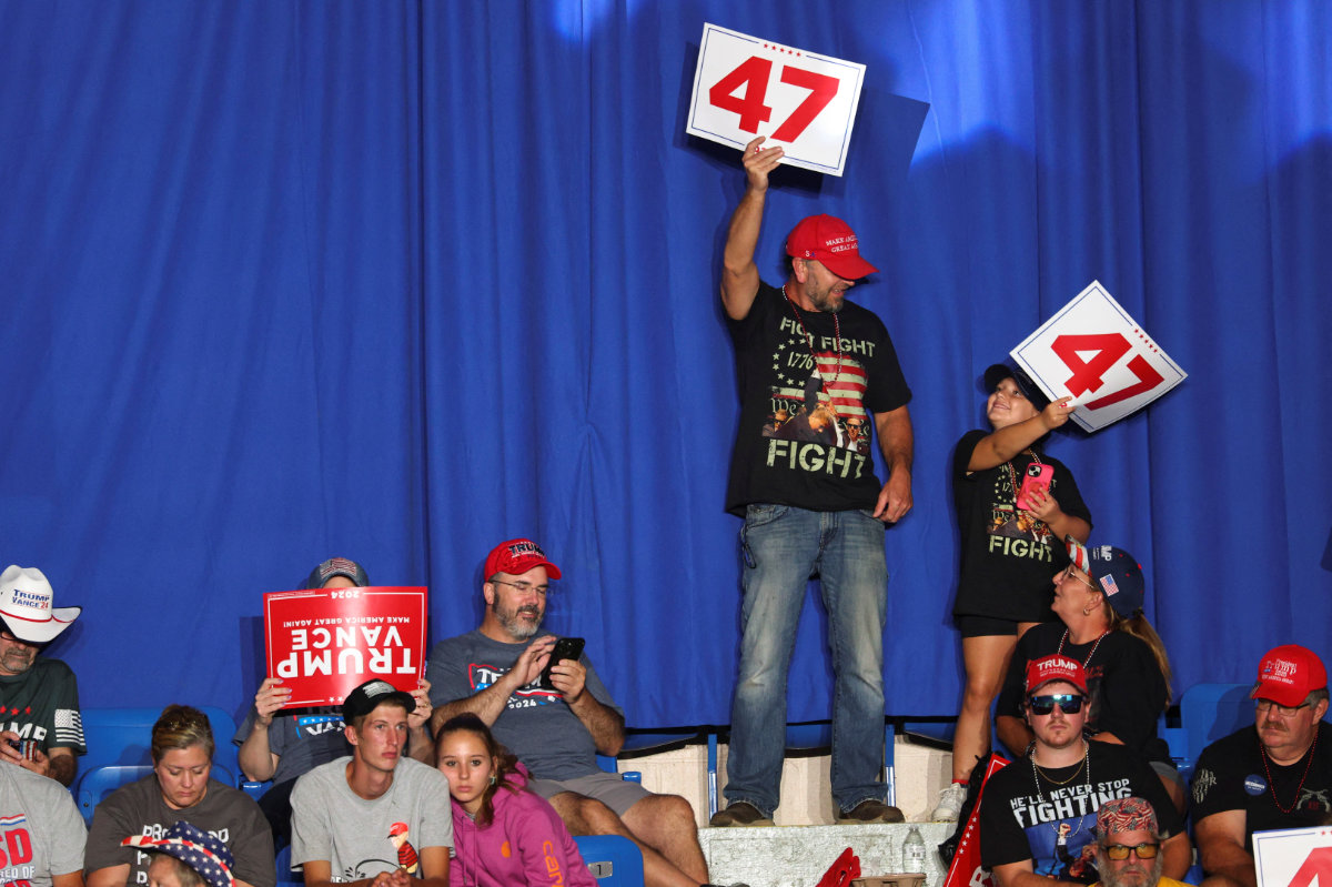 Attendees hold signs on the day Republican presidential nominee Donald Trump holds a rally at the Cambria County War Memorial Arena in Johnstown, Pennsylvania, on August 30, 2024. (REUTERS)