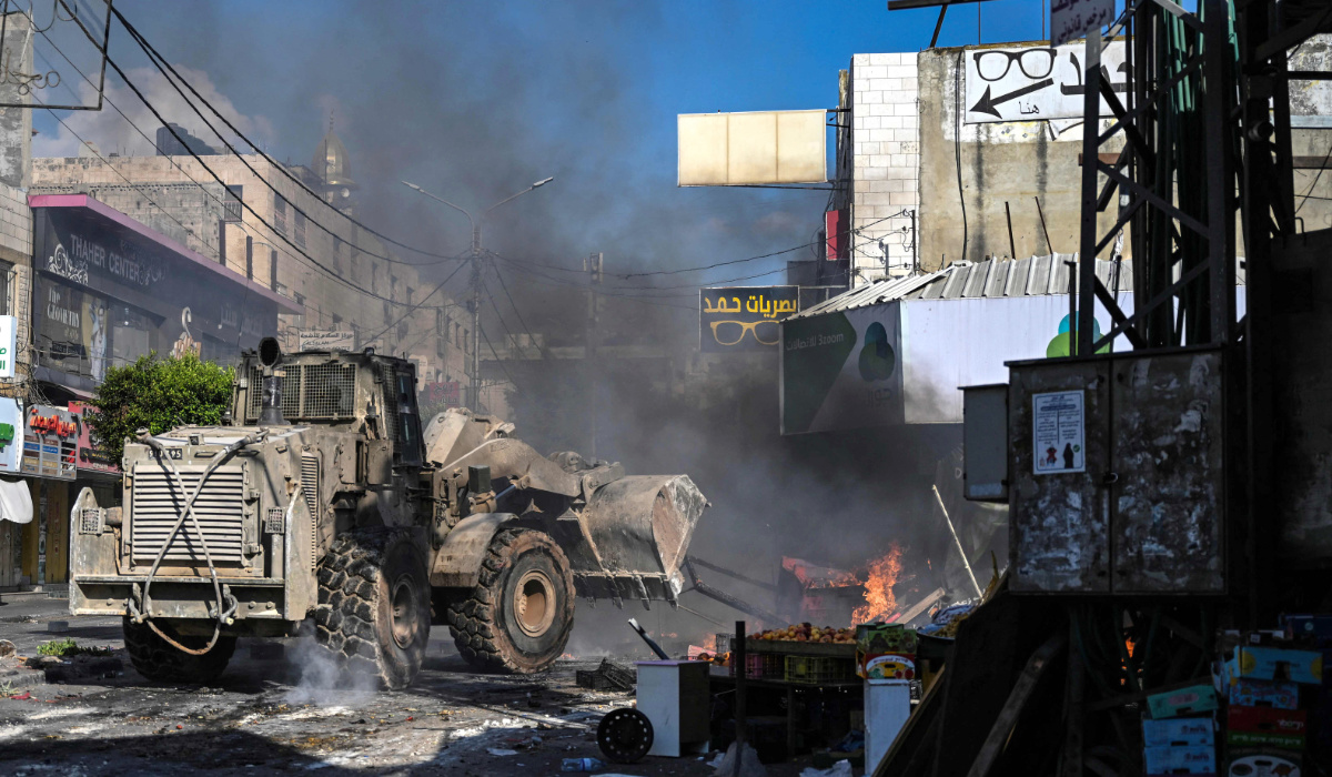 An Israeli bulldozer drives as fire breaks out in a fruit market in the occupied West Bank city of Jenin amid ongoing Israeli raids on August 31, 2024. (AFP)