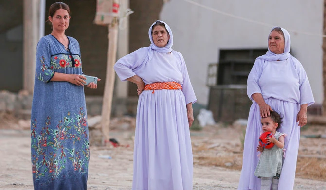 Yazidi women in traditional clothing stand outside their houses in the village of Dugure in Sinjar, Iraq, on July 16, 2024. (AP/File)