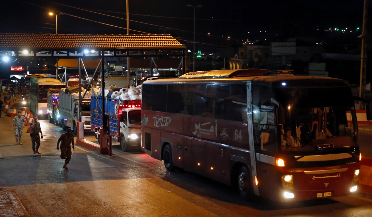 A convoy of buses and trucks carry Syrian refugees with their belongings cross into Syria at the Lebanese border crossing point of Masnaa, in Bekaa Valley, Lebanon, July 28, 2018. (AP)