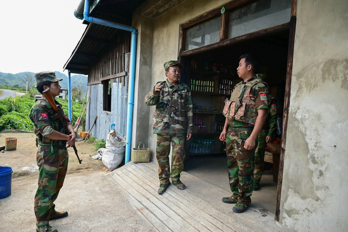 This photo taken on December 12, 2023 shows ethnic minority armed group Ta'ang National Liberation Army (TNLA) spokesman Tar Aik Kyaw (C) talking with soldiers at a checkpoint amid clashes with Myanmar's military near Namhsan Township in northern Shan State. (AFP)