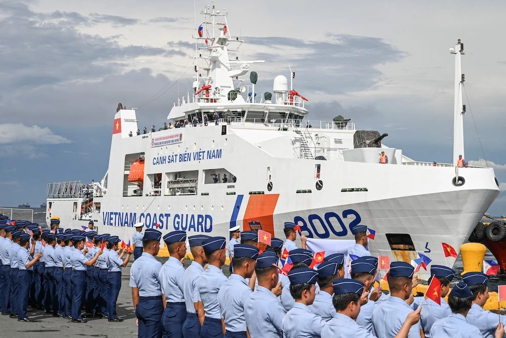Philippine Coast Guard personnel welcome Vietnam’s 90-meter ship CSB 8002 as it arrive at the port of Manila on Monday for a five-day port call on Aug. 5, 2024. (AFP)
