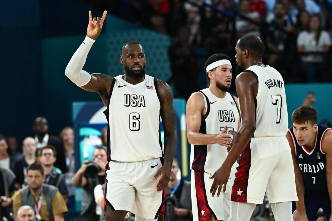 USA’s LeBron James, Devin Booker and Kevin Durant celebrate as Serbia’s Bogdan Bogdanovic (R) looks on at the end of the men’s semifinal basketball match between USA and Serbia during the Paris 2024 Olympic Games at the Bercy Arena in Paris on Aug. 8, 2024. (AFP)