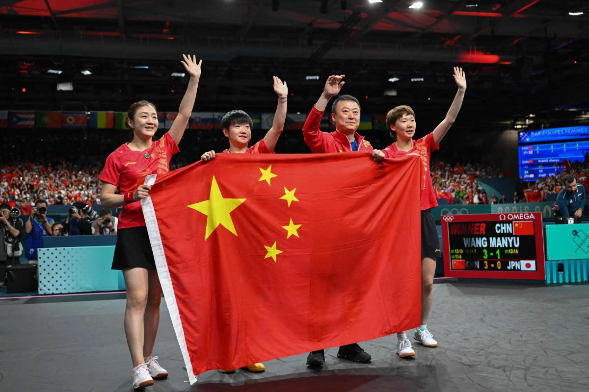 (L-R) Chen Meng, Sun Yingsha and Wang Manyu of Team China celebrate after winning the women's table tennis team gold medal match against Japan at the Paris 2024 Olympic Games on August 10, 2024. (AFP)