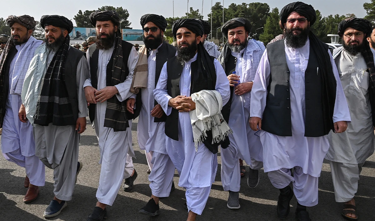 Taliban spokesman Zabihullah Mujahid (C, holding shawl) arrives as he is accompanied by officials to address a media conference at the airport in Kabul on August 31, 2021. (AFP/File)