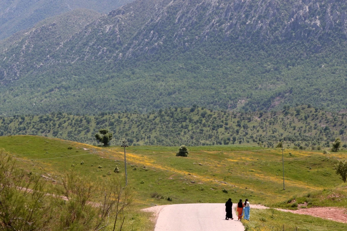In this picture taken on April 25, 2023, women walk along a road in the garden of their home in the village of Hiror near the Turkish border in northern Iraq's autonomous Kurdish region, where firefights occur between the Turkish army and fighters from the Kurdistan Workers' Party. (File/AFP)