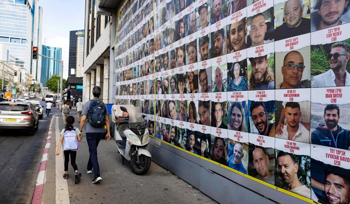 People walk past posters of Israelis held hostage by Palestinian militants in Gaza since the October 7 attacks, in Tel Aviv on August 11, 2024, amid the ongoing conflict in the Gaza Strip between Israel and the militant Hamas movement. (AFP)