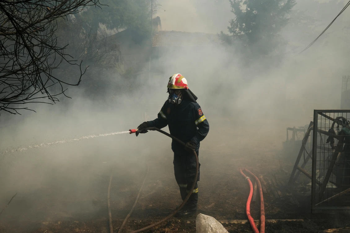 A firefighter tries to extinguish a wildfire burning in Nea Penteli, Greece, August 12, 2024. (Reuters)