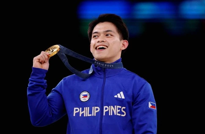 Double-gold medalist Carlos Edriel Yulo of Philippines celebrates on the podium in Paris, France on Aug. 4, 2024. (Reuters)