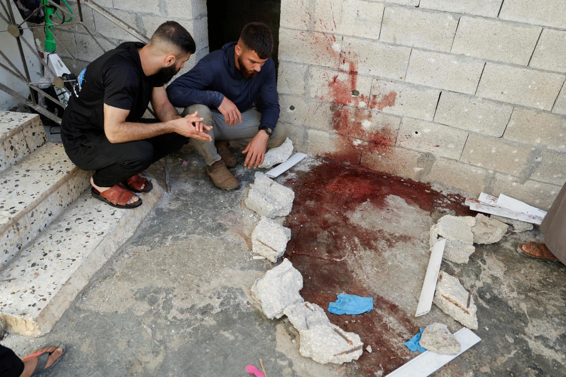 Palestinians react next to a bloodied ground at a house, during an Israeli raid, in Tubas, in the Israeli-occupied West Bank, August 14, 2024. (Reuters)