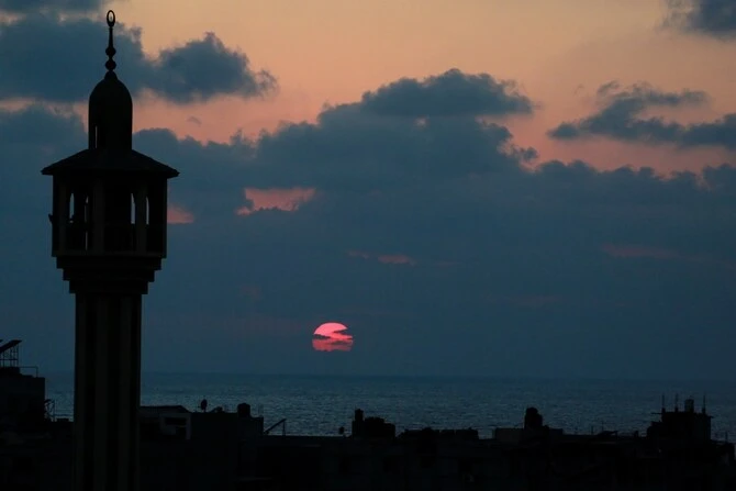 The minaret of a mosque is silhouetted in Deir al-Balah in the central Gaza. (AFP)