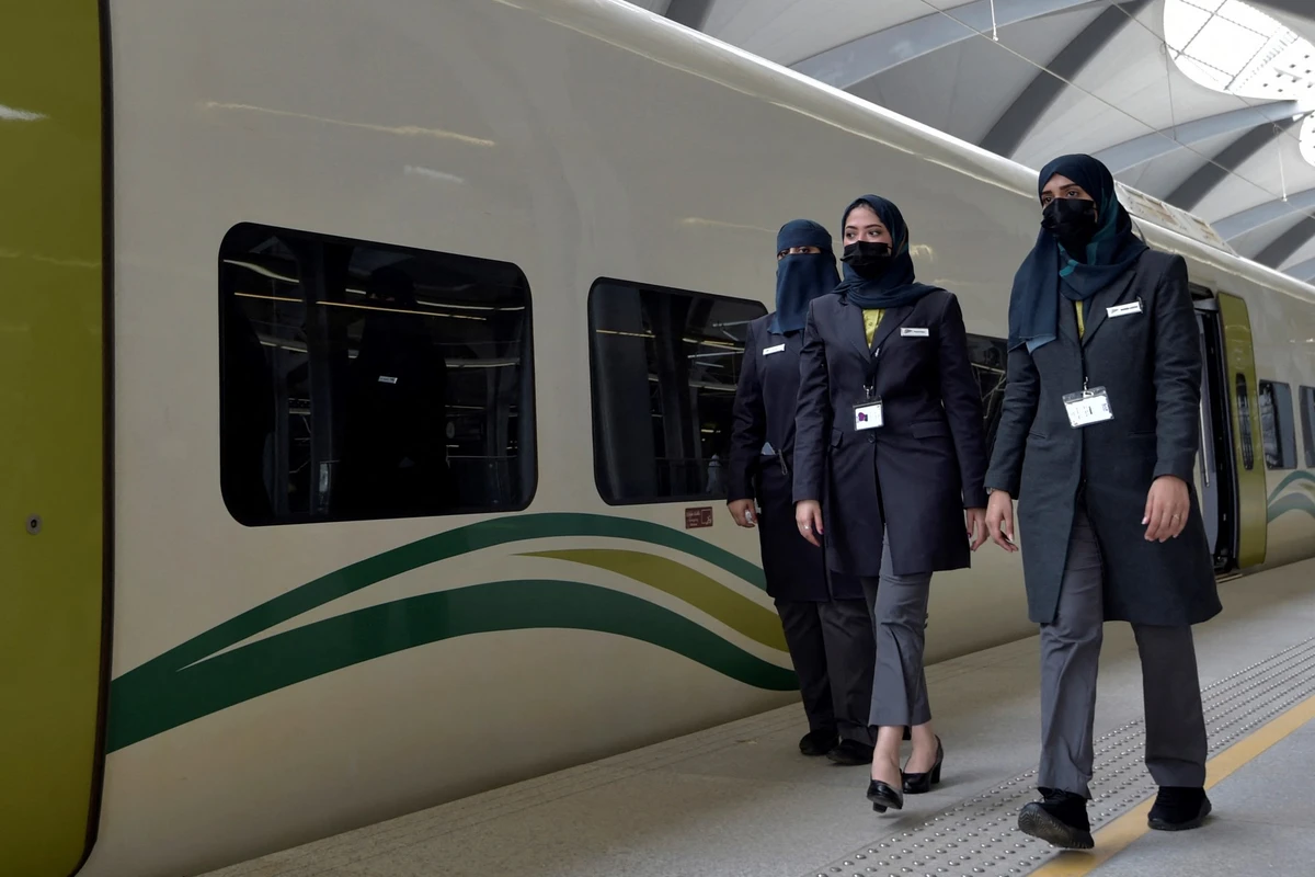 Saudi conductors walk beside a high-speed train ferrying pilgrims to Mecca, in Saudi Arabia's Red Sea coastal city of Jeddah, on January 22, 2023. (AFP)