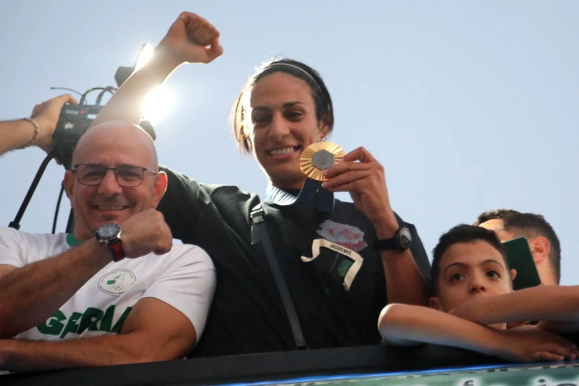 Algerian gold medallist Imane Khelif greets crowds during a bus tour in her hometown city of Tiaret on Aug. 16, 2024. (AFP)