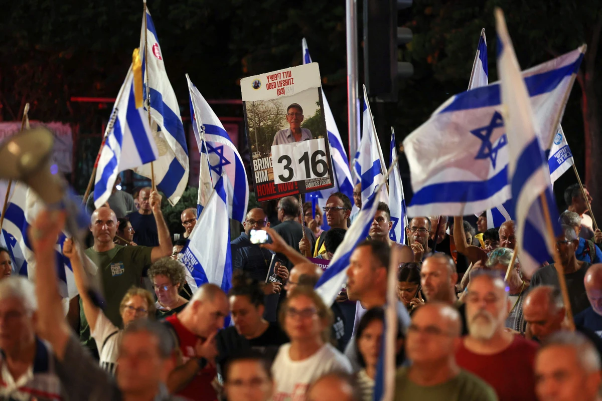 Relatives and supporters of Israelis held hostage by Palestinian militants in Gaza since the October 7 attacks, wave flags as they demonstrate calling for their release in the port city of Haifa on August 17, 2024, amid the ongoing conflict between Israel and Hamas. (AFP)