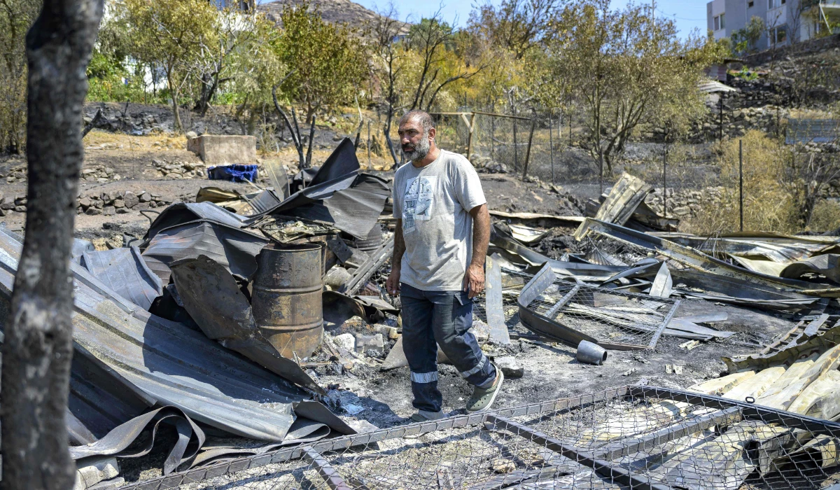 Abdullah Ozata, 43, walks among debris on the site of his burnt barn where his animals perished in a wildfire in the Sancakli village, in Turkey's western province of Izmir on August 18, 2024. (AFP)