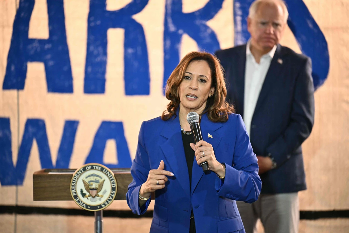 US Vice President and Democratic presidential candidate Kamala Harris speaks as her running mate Minnesota Governor Tim Walz looks on during a stop on their campaign bus tour in Rochester, Pennsylvania, on August 18, 2024. (AFP)