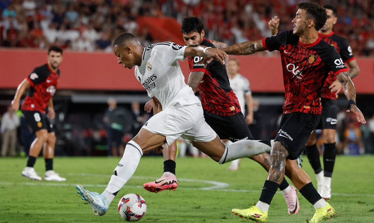 Real Mallorca's Spanish midfielder #18 Antonio Sanchez (R) and Real Madrid's French forward #09 Kylian Mbappe fight for the ball during the Spanish league football match between RCD Mallorca and Real Madrid CF at the Mallorca Son Moix stadium in Palma de Mallorca on August 18, 2024. (AFP)