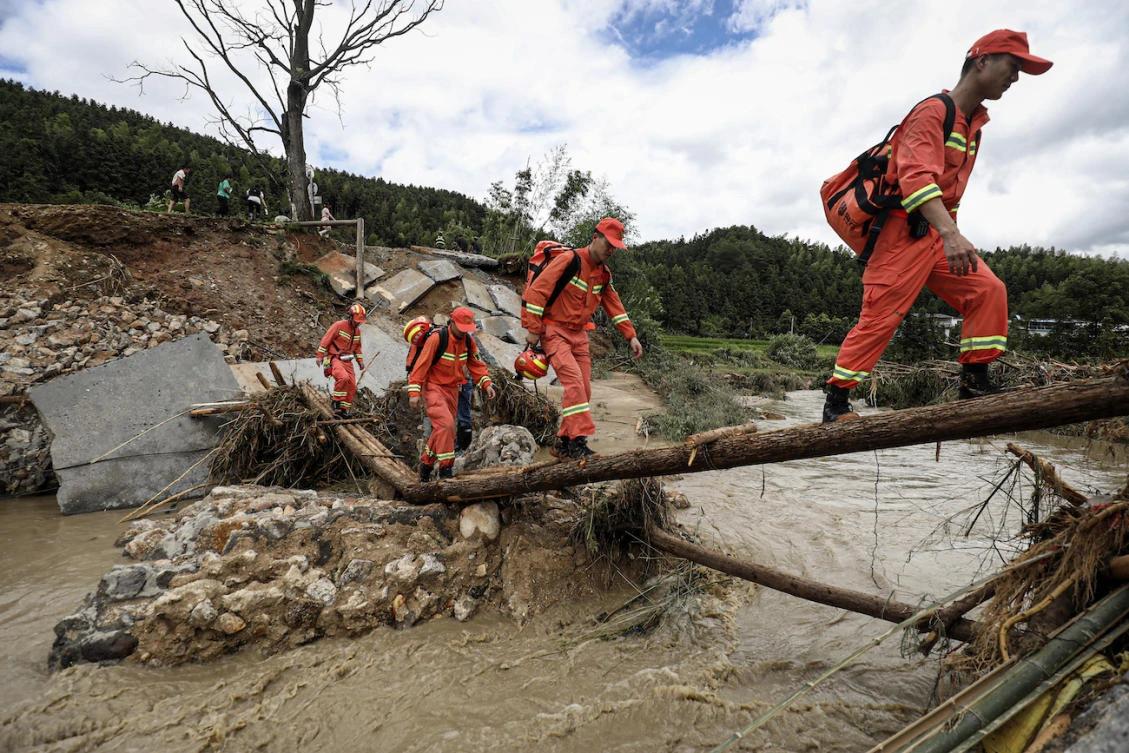 Members of a rescue team walk to a flood-affected area in Zixing, in central China’s Hunan province. (File/AFP)