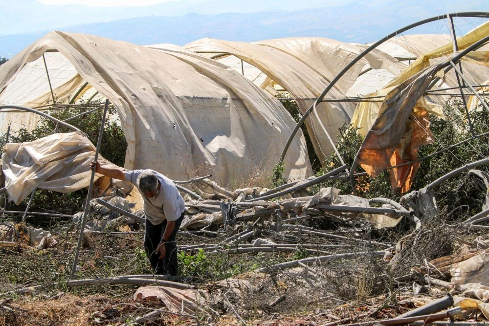 A man salvages the remains of a destroyed greenhouse after the overnight Israeli bombardment of Sarein, in the Bekaa valley, Lebanon, Aug. 20, 2024. (AFP)