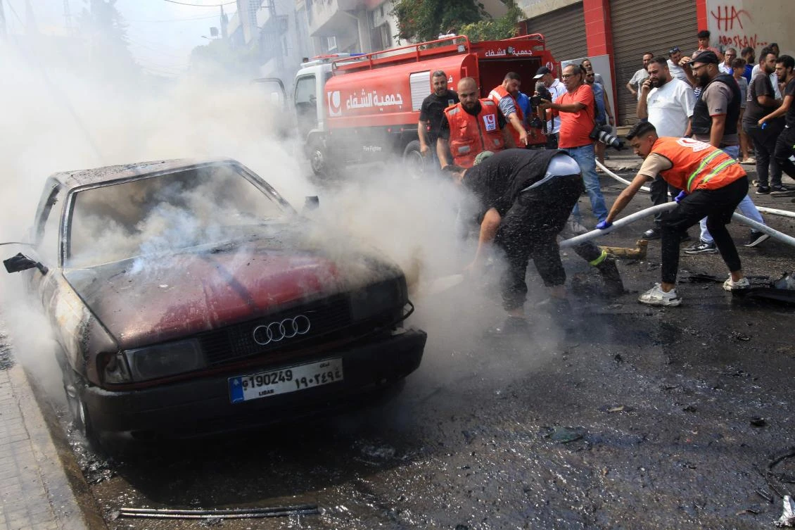 Lebanese firefighters put out a fire in a car after an Israeli strike in the southern city of Sidon on August 21, 2024. (AFP)