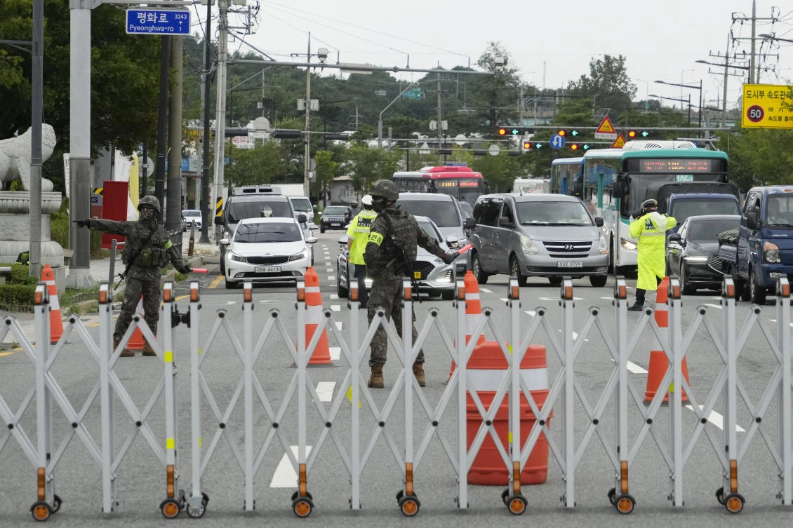 Thousands of pedestrians and government employees cleared from streets and offices, while traffic stopped in some areas, causing confusion and frustration. Above, army and police personnel control traffic in Seoul. (AP)
