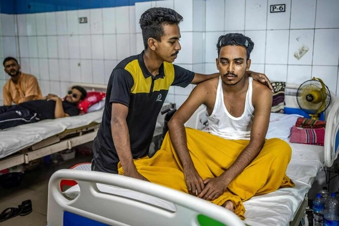 Omar Faruq (R) who lost his sight as he was wounded by shotgun pellets during the student-led uprising that ousted the 15-year rule of ex-premier Sheikh Hasina, sits on a bed at National Institute of Opthalmology and Hospital in Dhaka on August 20, 2024. (AFP)