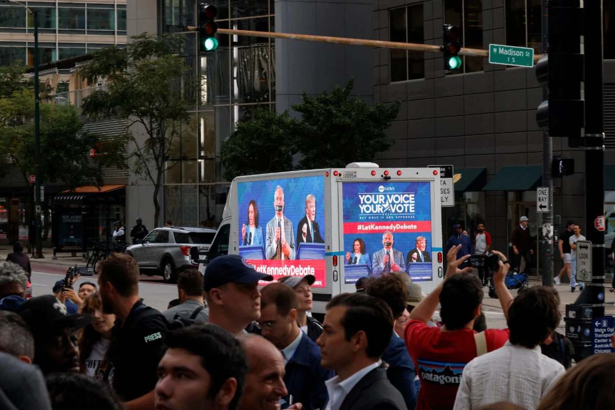 A bus demanding Robert F. Kennedy's participation in a debate drives past a protest near the Israeli consulate, as the Democratic National Convention is held, in Chicago, Illinois, on August 20, 2024. (REUTERS)