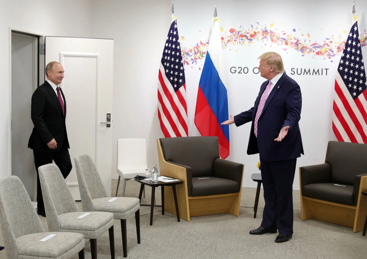 In this photo taken on June 28, 2019, US President Donald Trump (R) welcomes Russia's President Vladimir Putin during a meeting on the sidelines of the G20 summit in Osaka, Japan. (SPUTNIK photo via AFP)