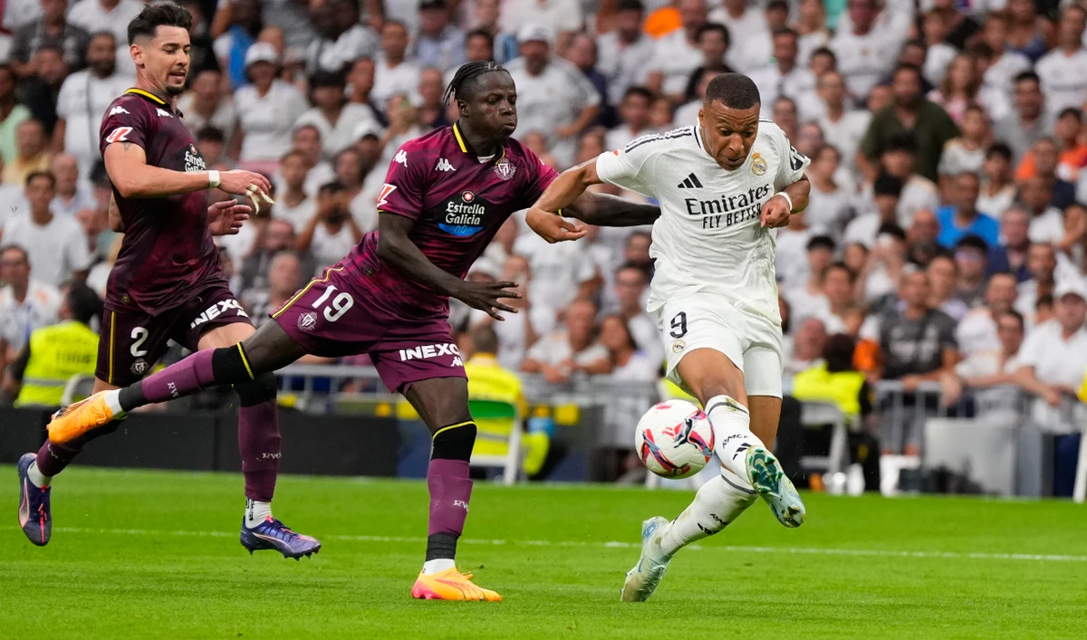 Real Madrid's Kylian Mbappe, right, and Valladolid's Amath Ndiaye challenge for the ball during the Spanish La Liga soccer match between Real Madrid and Valladolid at the Santiago Bernabeu stadium in Madrid, Spain, Sunday, Aug. 25, 2024. (AP)