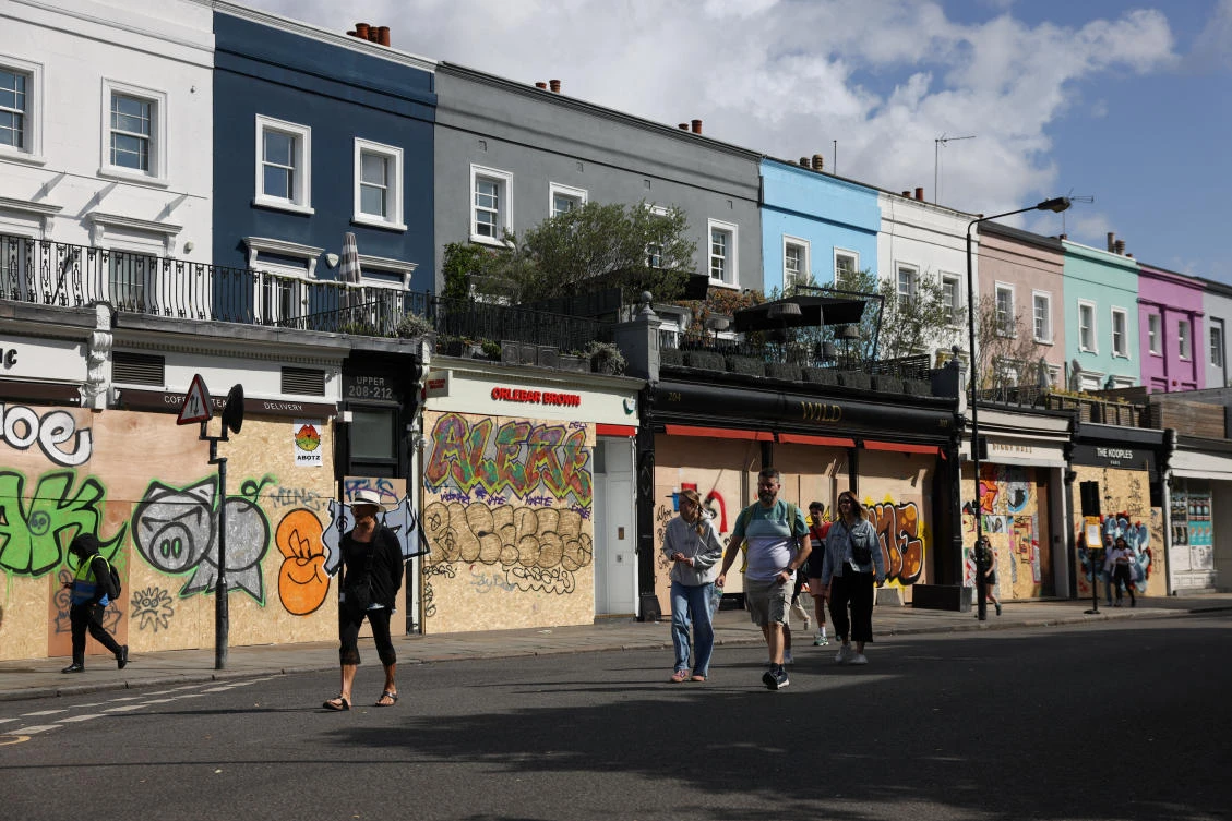 People walk on a street, as local businesses are boarded up in preparation for the Notting Hill Carnival, in London, Britain, August 25, 2024. (Reuters)