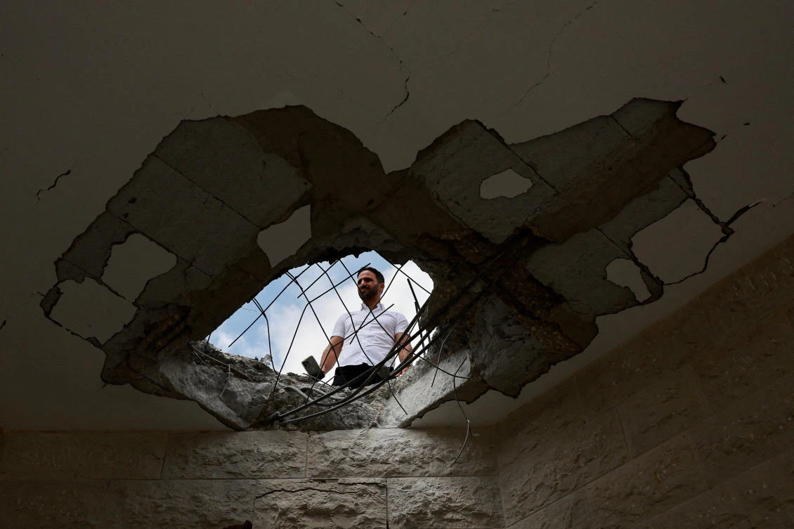 An official property surveyor assesses the damage to a residential building following a direct-hit from a projectile, after Hezbollah launched hundreds of rockets and drones towards Israel. (Reuters)
