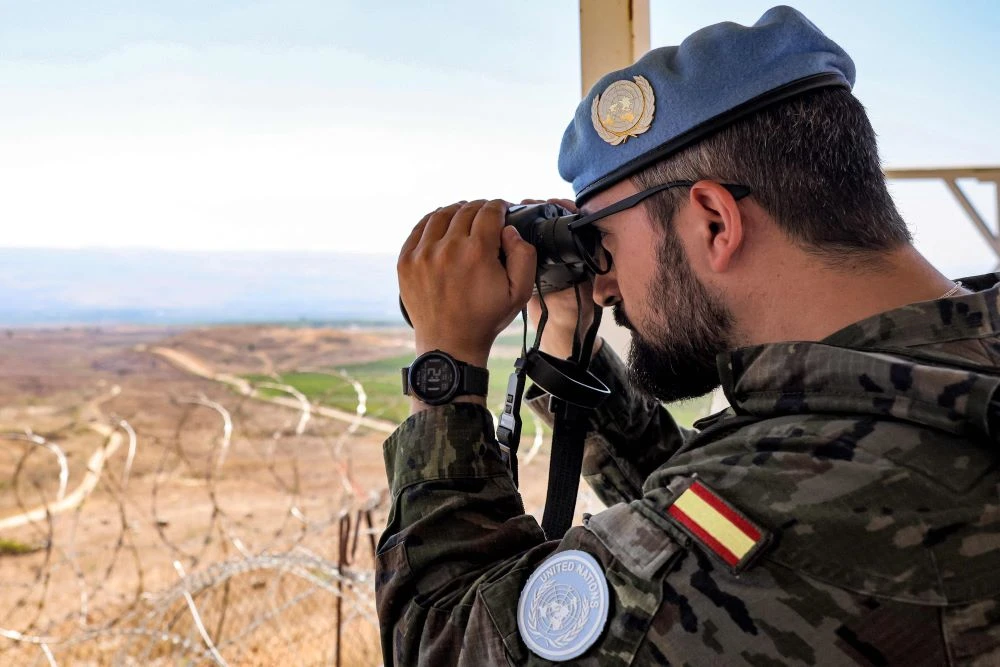 A peacekeeper of the Spanish Contingent looks through binoculars from a watchpost at the United Nations Interim Force in Lebanon (UNIFIL) barracks near Khiam, southern Lebanon, Aug. 23, 2024. (AFP)