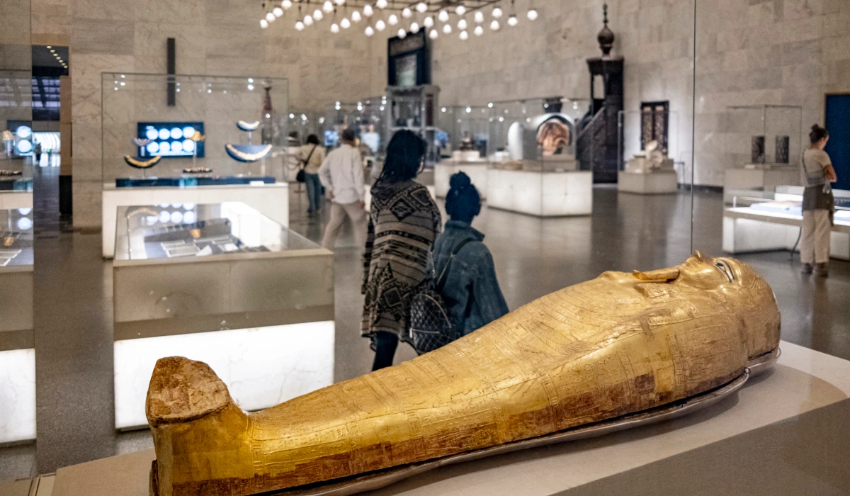 Visitors walk past the gilded sarcophagus of Nedjemankh, a priest of the ram-god Heryshaf dating to the late Ptolemaic period (150-50 BC), on display at the National Museum of Egyptian Civilisation in the district of Fustat of Egypt's capital Cairo on November 13, 2022. (AFP)