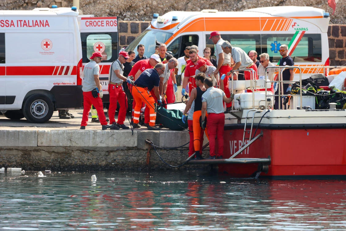 Italian firefighters and health workers carry a body bag with a victim after a sailboat sank off the coast of Porticello, nosthwestern of Sicily Island. (File/AFP)