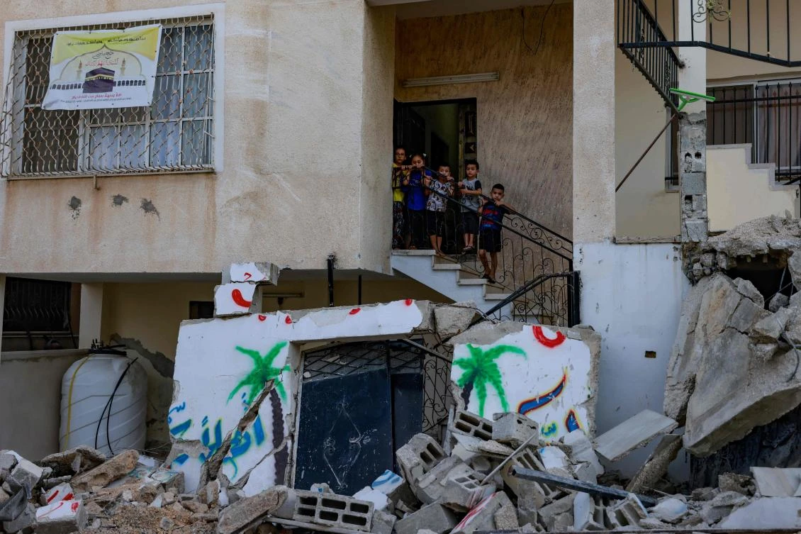 Palestinian children stand on the stairway of a house, standing amid the destruction caused by an Israeli raid in the Nur Shams camp near the city of Tulkarem in the Israeli-occupied West Bank on August 28, 2024. (AFP)