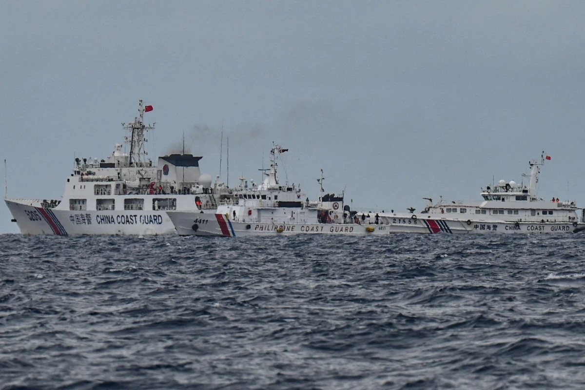China Coast Guard ships (background L and R) are seen past the Philippine Coast Guard ship BRP Cape Engano (C), during a supply mission to Sabina Shoal in disputed waters of the South China Sea on August 26, 2024. (AFP)