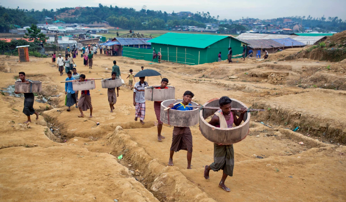 Rohingya Muslims carrying construction material walk towards to a refugee camp in Bangladesh, Friday, Nov. 17, 2017. (AP)