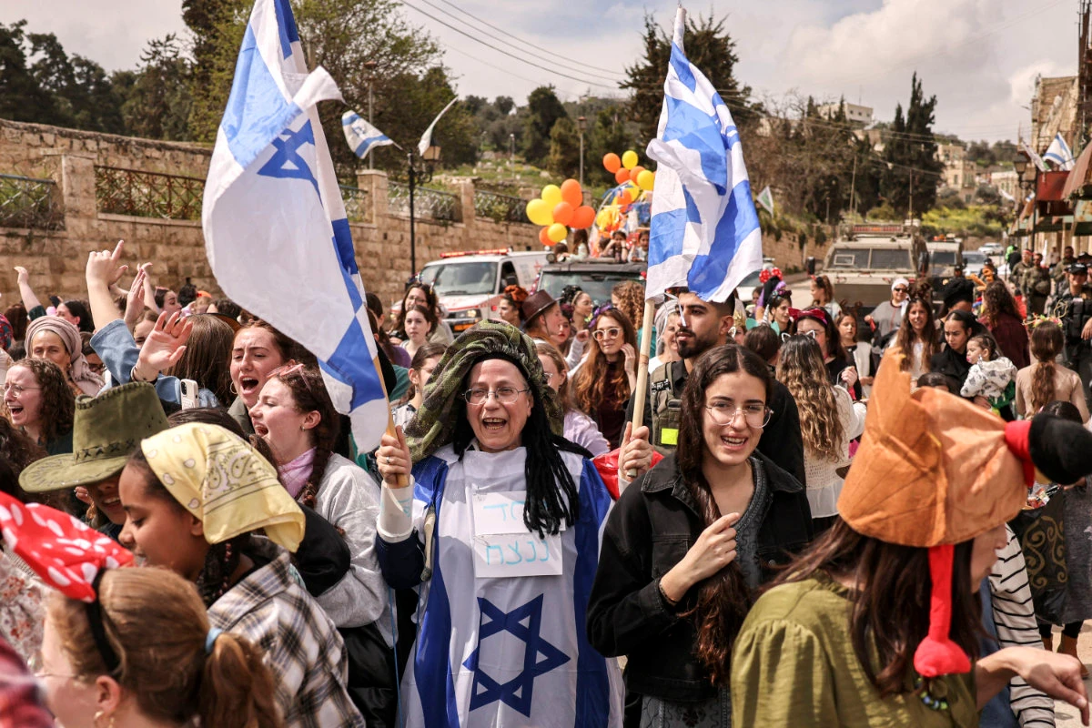 Orit Malka Strook, Israeli minister of settlements, holds Israeli flags during a celebration in Hebron on March 24, 2024. (AFP)