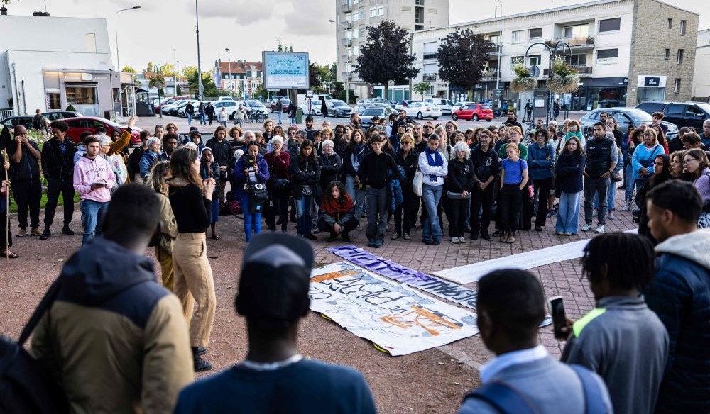 People stand around a banner with the names of migrants who died crossing the Channel, Calais, France, Sept. 16, 2024. (AFP)