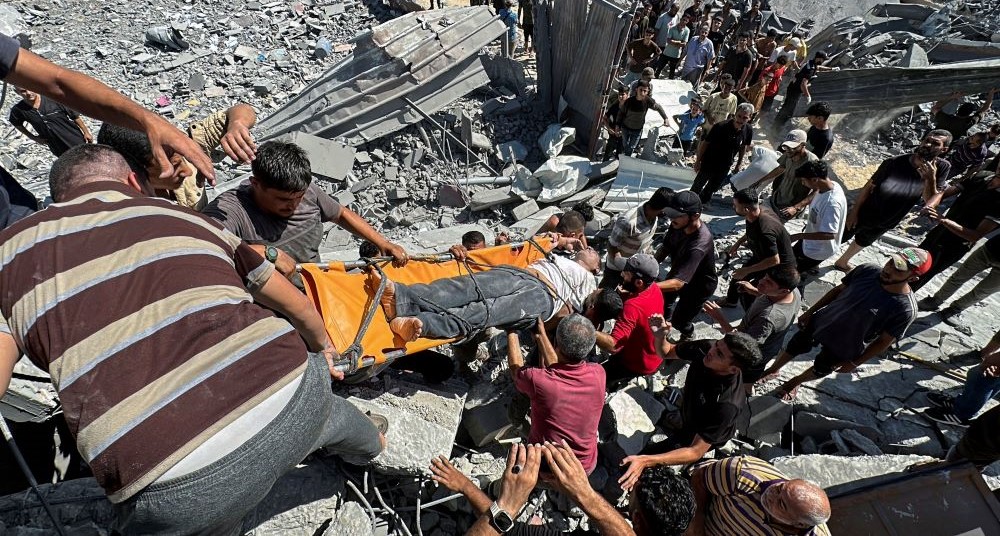 Palestinians carry a wounded man after an Israeli strike on a residential building in Nuseirat, Gaza, Sept. 30, 2024. (Reuters)