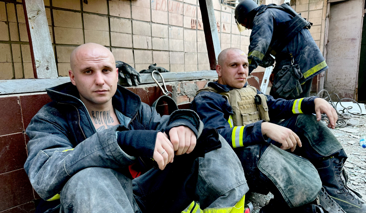 Emergency workers rest near the site where a hotel was hit by a missile in Kramatorsk, Donetsk region, in Ukraine. (REUTERS)