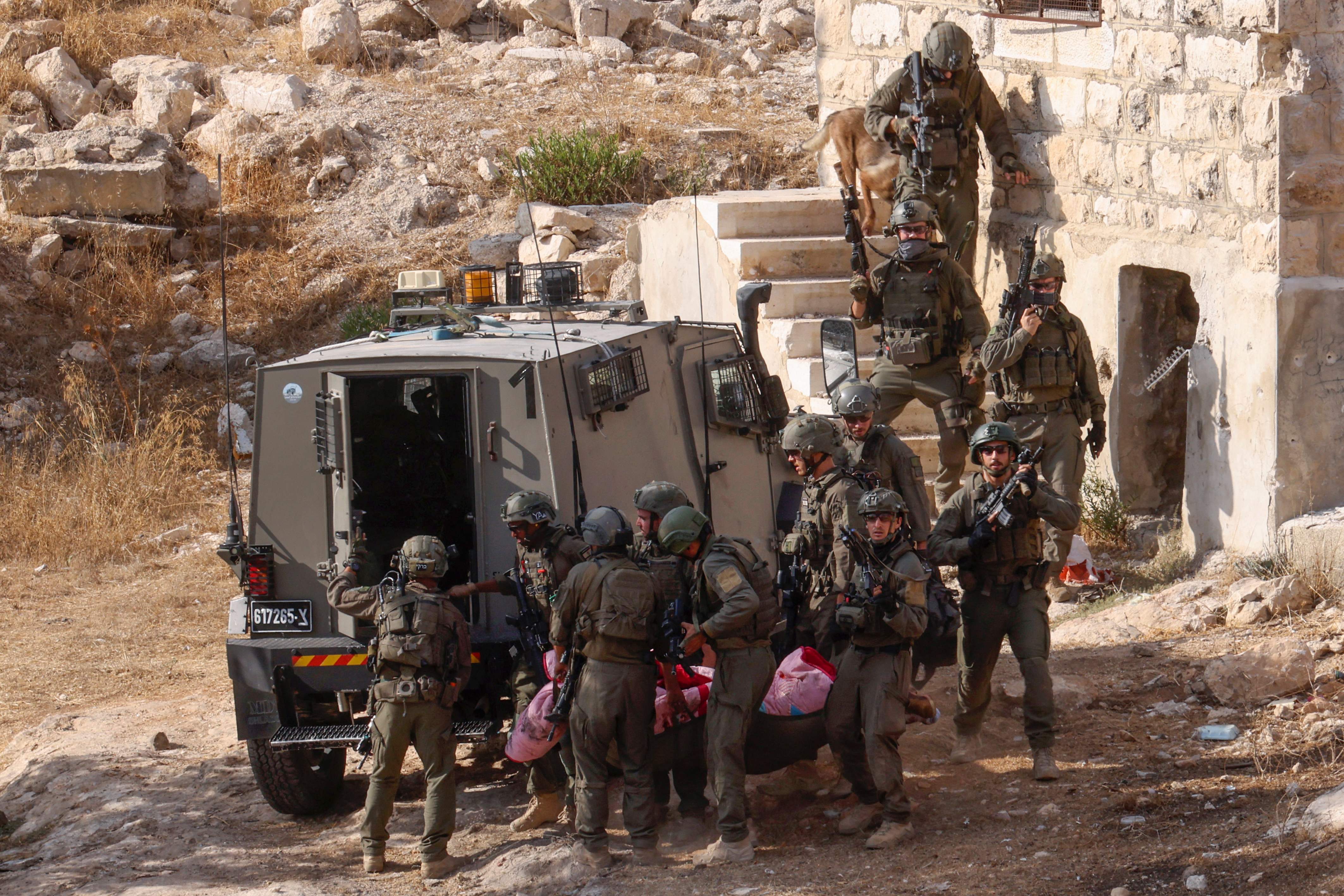 Israeli security forces transport the body of a Palestinian man from an old building during a raid in Hebron city in the occupied West Bank on September 1, 2024. (AFP)