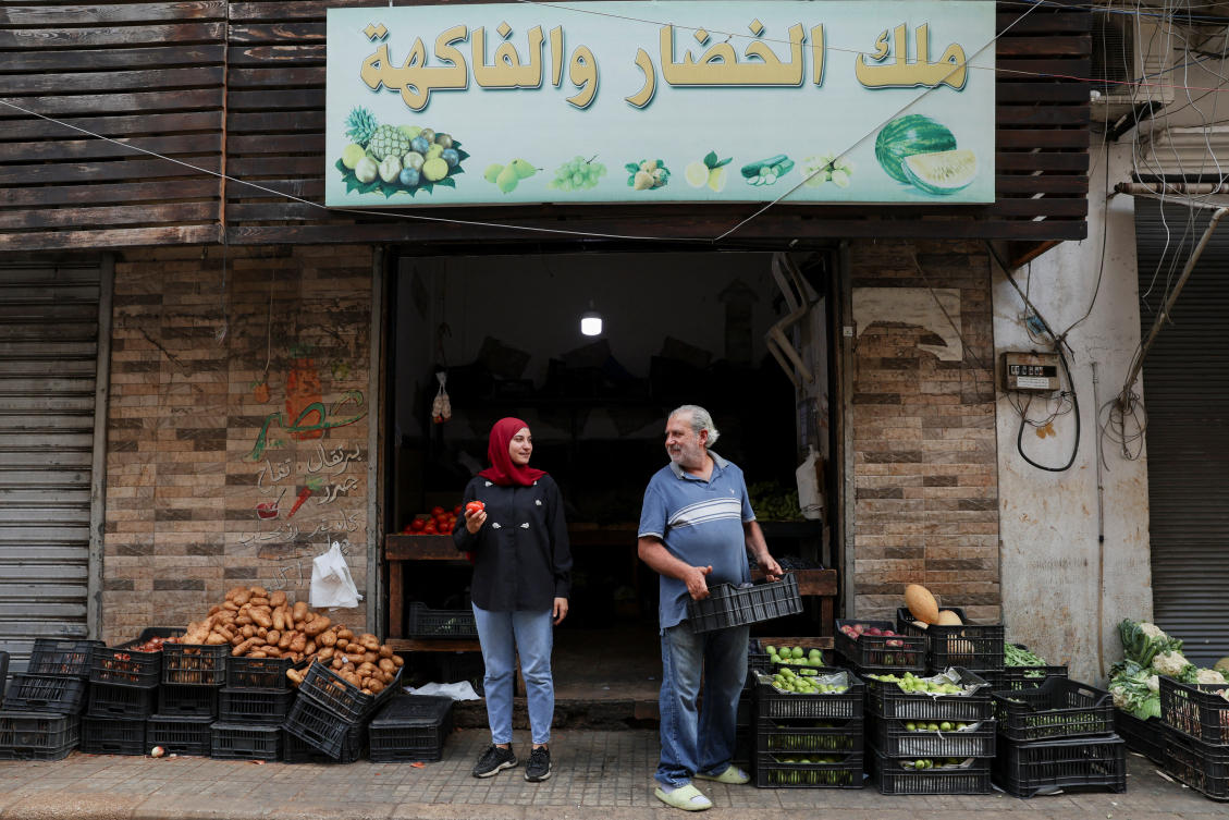 Fruits and vegetable shop owner, Hussein Fakih, and his daughter, Alaa, in front of their shop in Bourj Hammoud, Lebanon. (Reuters)