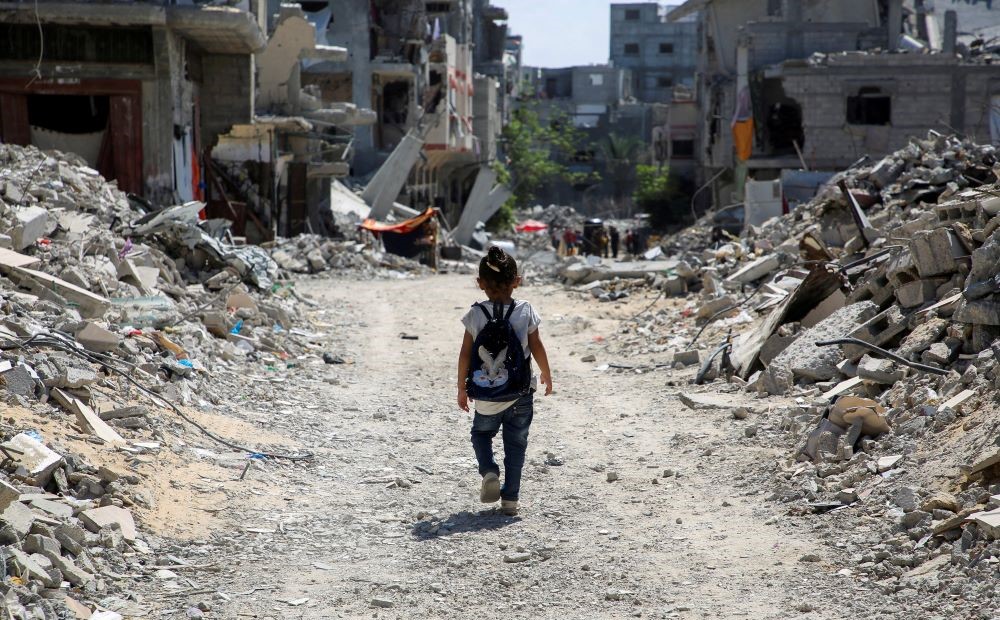 A Palestinian student walks home after attending a class in a tent set up on the rubble of the house of teacher Israa Abu Mustafa, Khan Younis, southern Gaza Strip, Sept. 4, 2024. (Reuters)