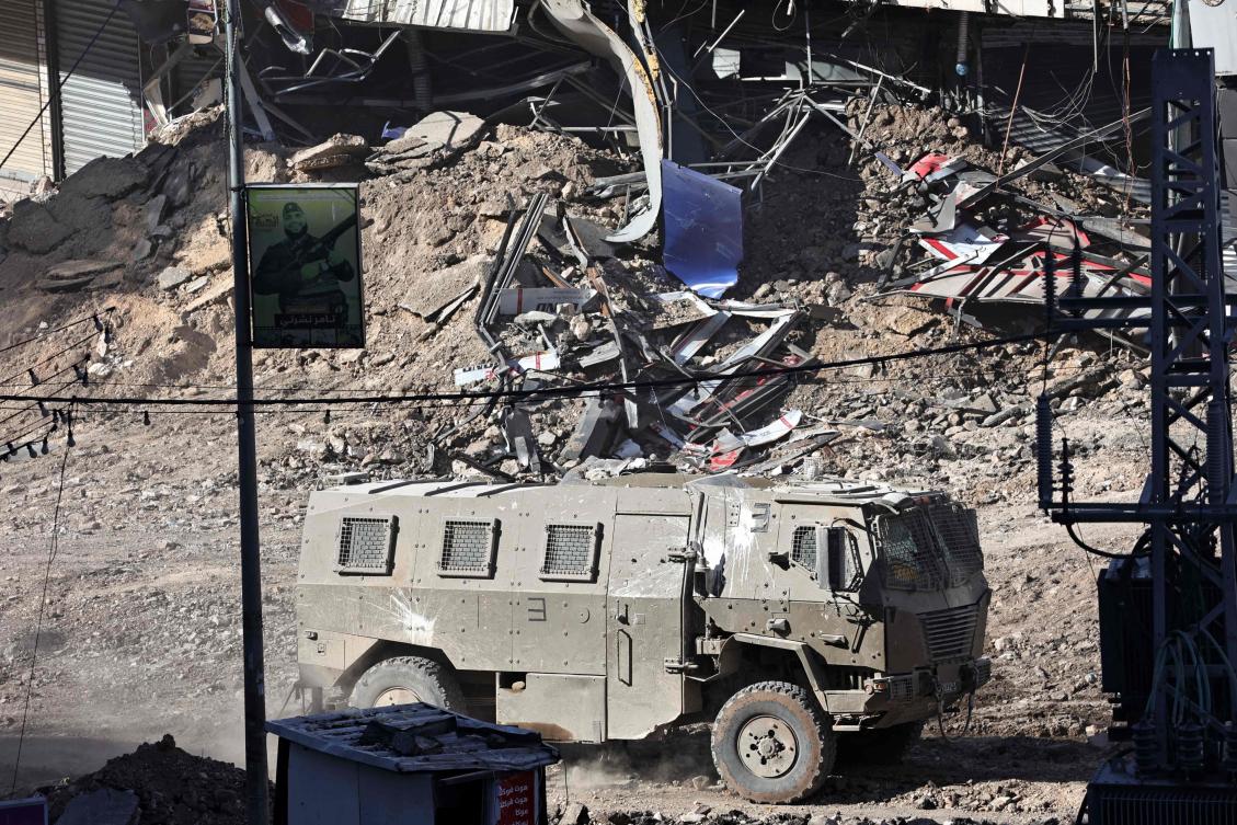 An Israeli armored vehicle drives along a devastated street in Jenin in the occupied West Bank on September 4, 2024, during an Israeli military raid. (AFP)