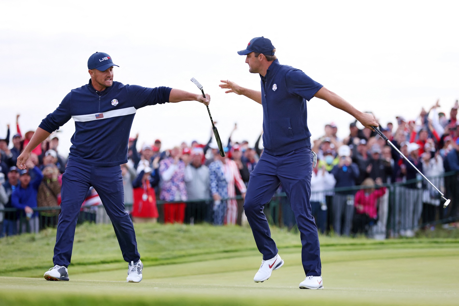 Bryson DeChambeau of the US (L) and teammate Scottie Scheffler celebrate on the 15th green during Saturday afternoon fourball matches of the 43rd Ryder Cup at Whistling Straits on Sept. 25, 2021 in Kohler, Wisconsin. (AFP)