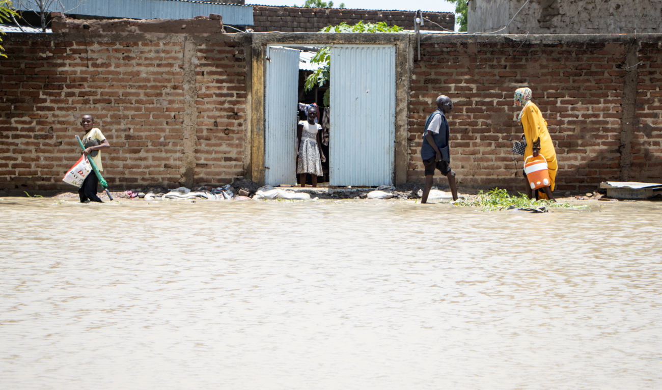 Residents of Boutal-Bagar district walk through a flooded street in N’Djamena on August 5, 2022, following the first major rains of the season. (AFP/File)