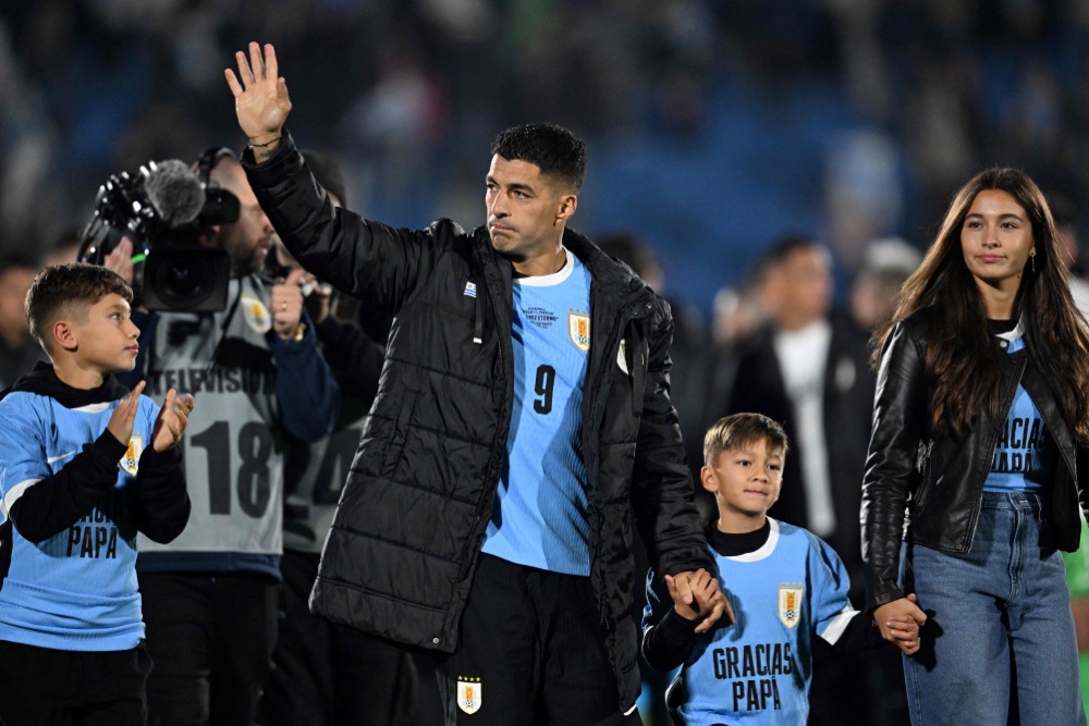 Uruguay's forward Luis Suarez (2nd L) waves next to his children (L to R) Benjamin, Lautaro, and Delfina. (AFP)
